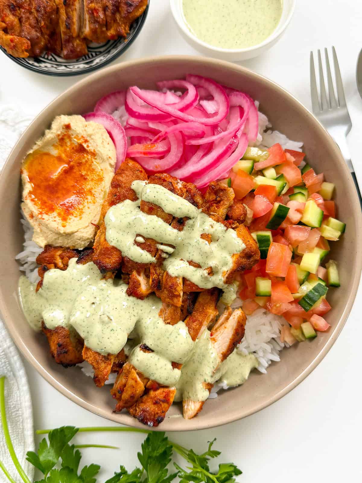 Harissa Honey Chicken in a bowl with lemon herb tahini top angle