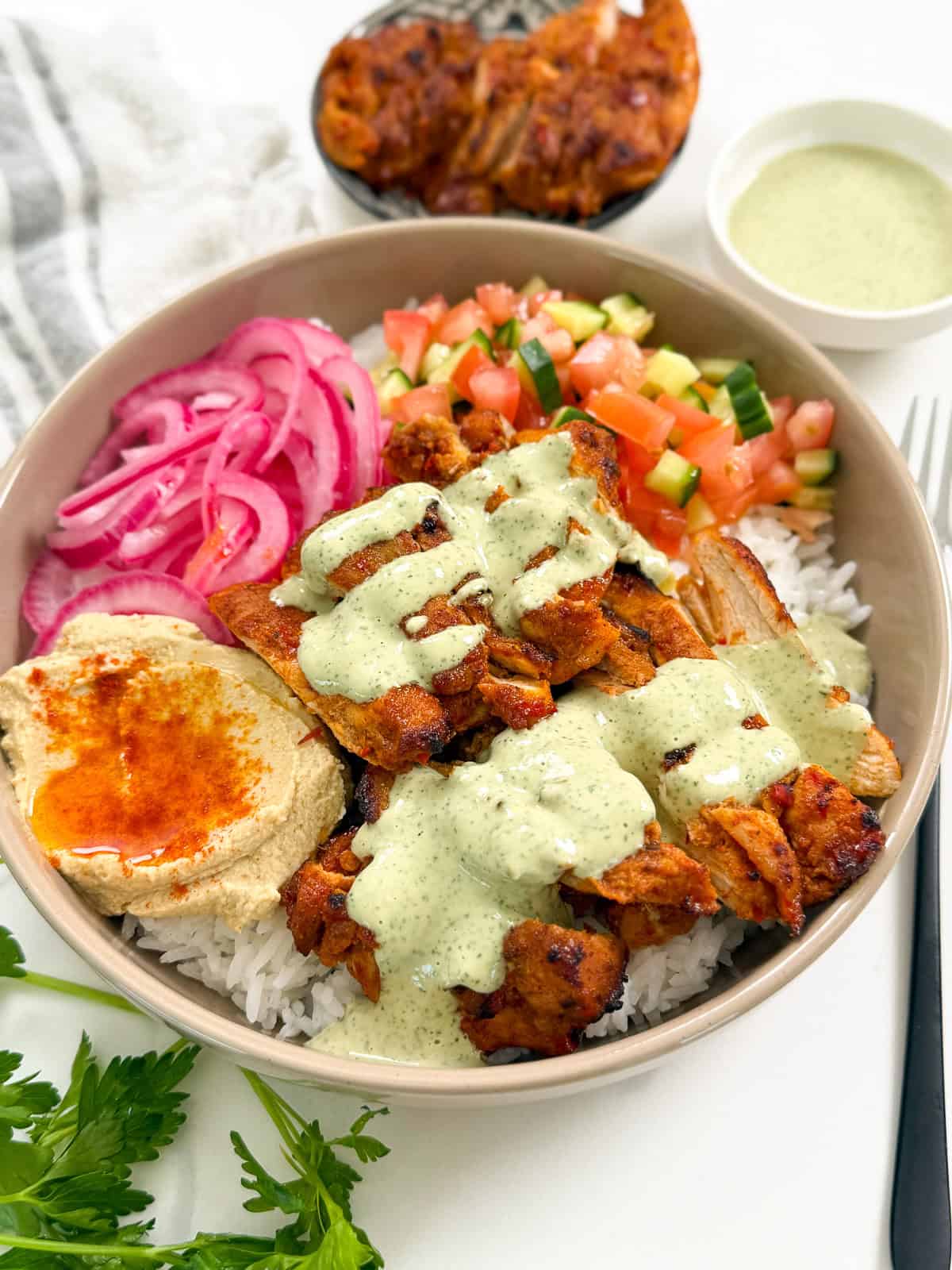Harissa Honey Chicken in a bowl with lemon herb tahini side angle