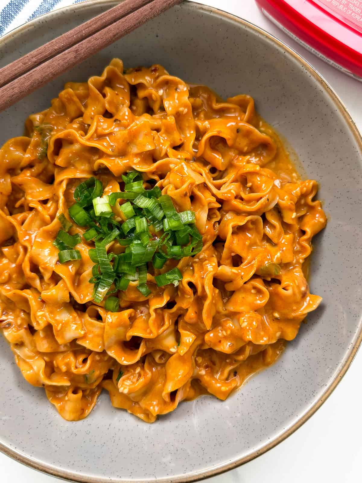 Peanut Gochujang Chili Noodles with chopsticks and green onions top view