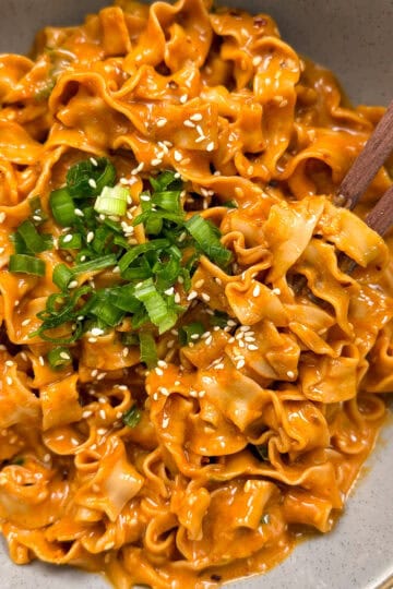 Peanut Gochujang Chili Noodles with chopsticks and green onions featured view