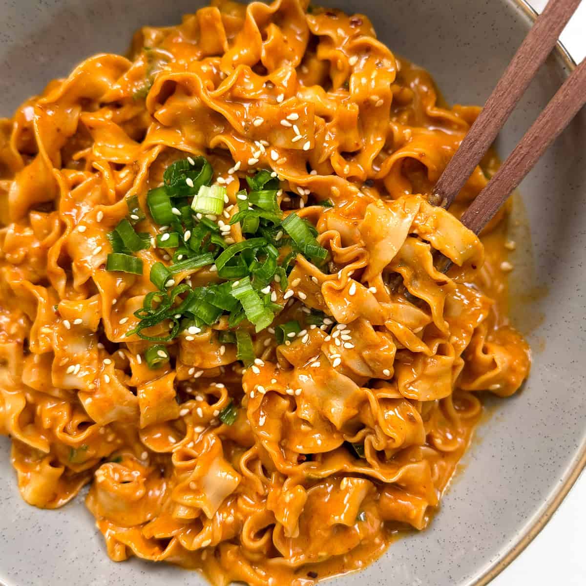 Peanut Gochujang Chili Noodles with chopsticks and green onions featured view