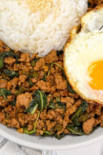 Pad Kra Pao (Ground Pork & Holy Basil Stir-Fry) in a bowl with white rice and fried egg featured view