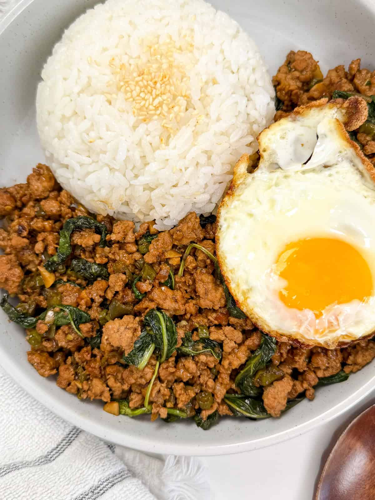 Pad Kra Pao (Ground Pork & Holy Basil Stir-Fry) in a bowl with white rice and fried egg main view