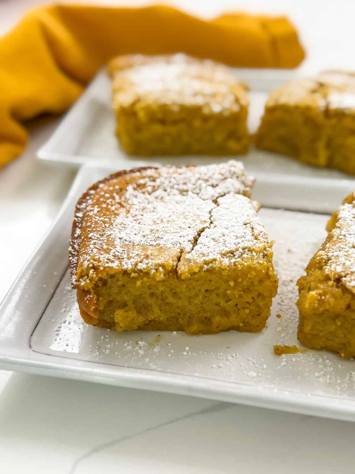 Pumpkin Butter Mochi on a plate with powdered sugar top view