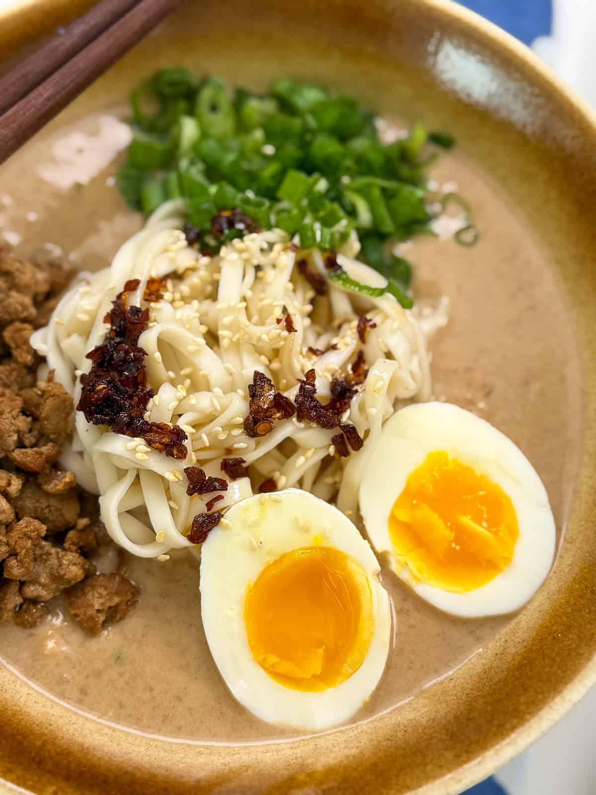 Creamy Peanut Miso Ramen with ground pork, eggs, and green onion zoomed in