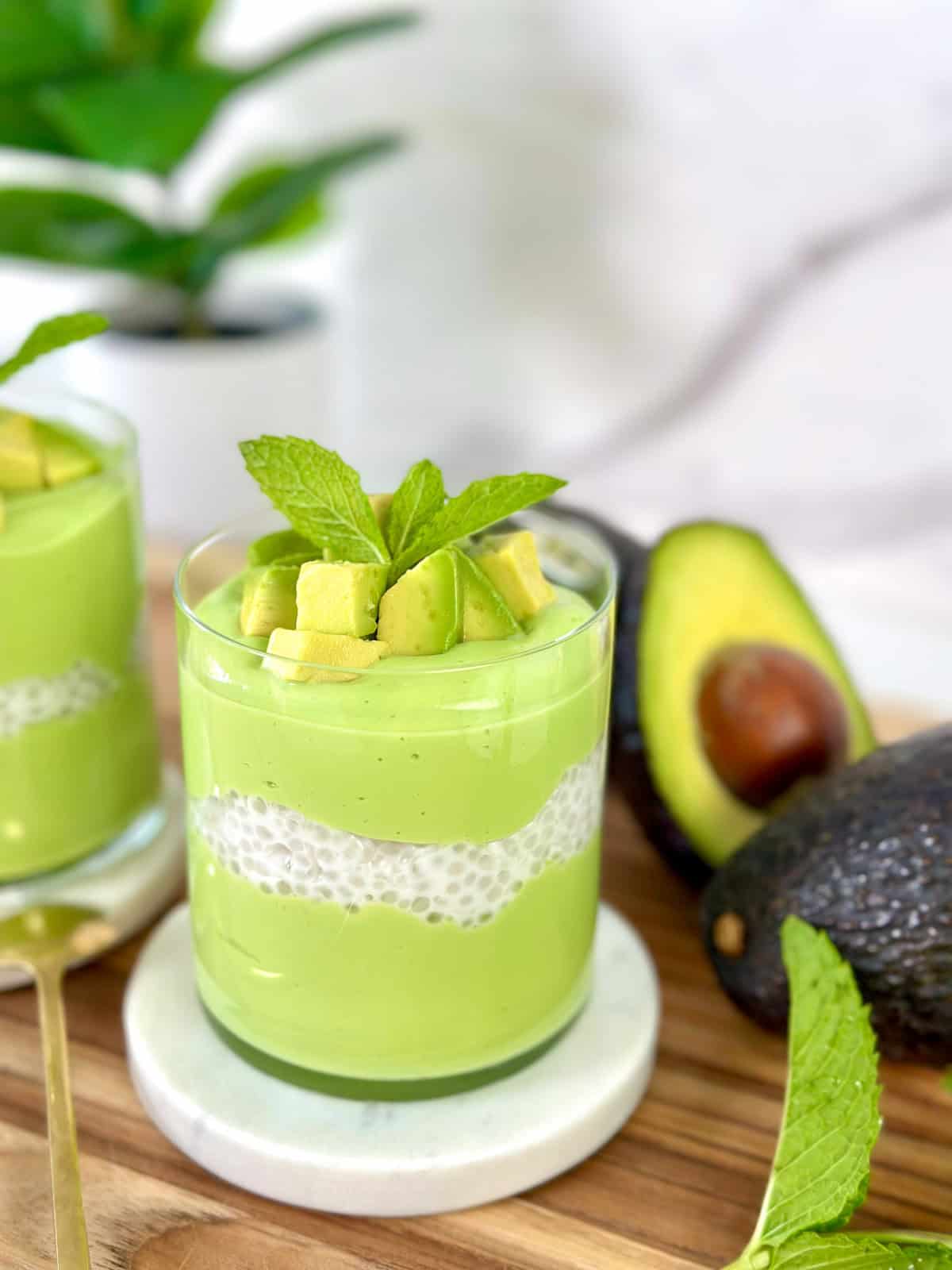 Avocado sago in a cup with fresh avocado chunks and mint leaf on top main view