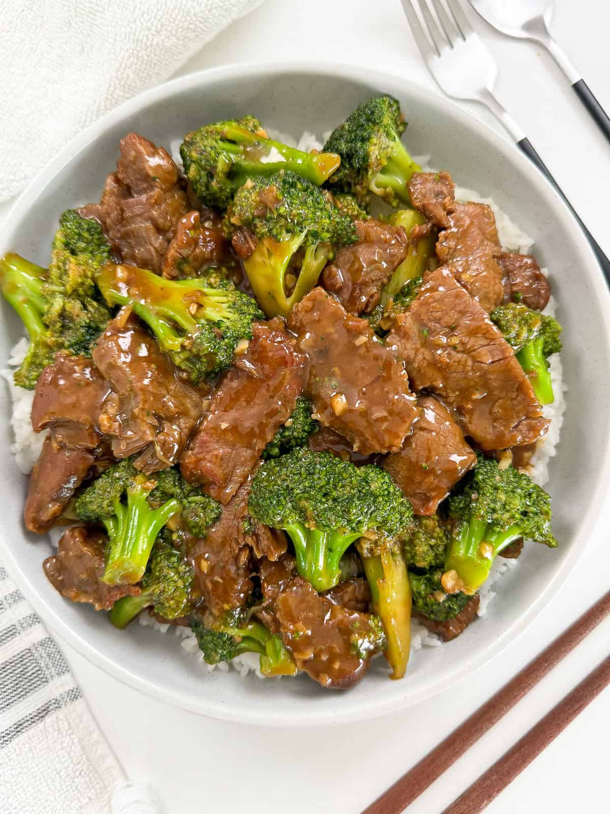 Beef and broccoli over rice in a bowl top down view