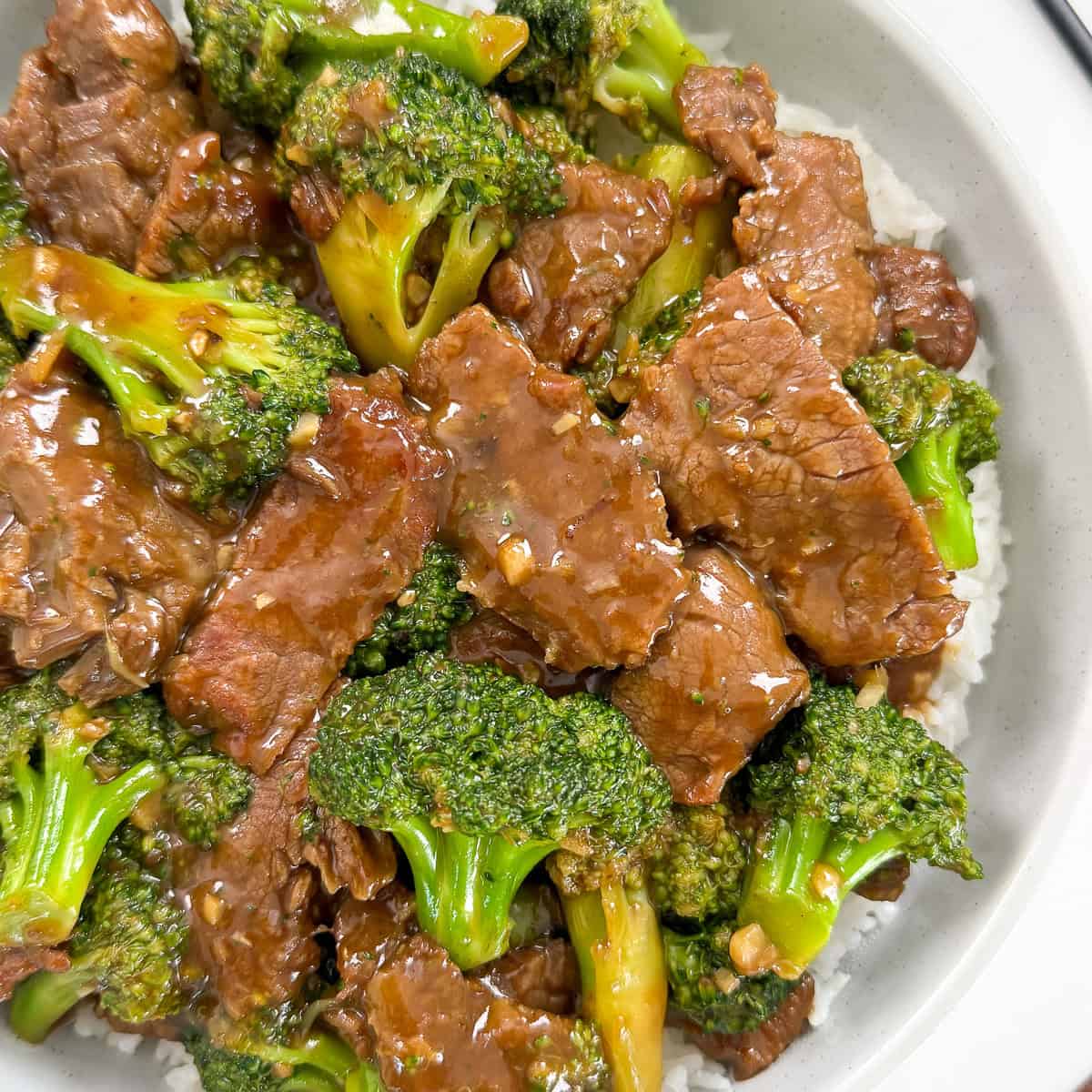 Beef and broccoli over rice in a bowl featured view