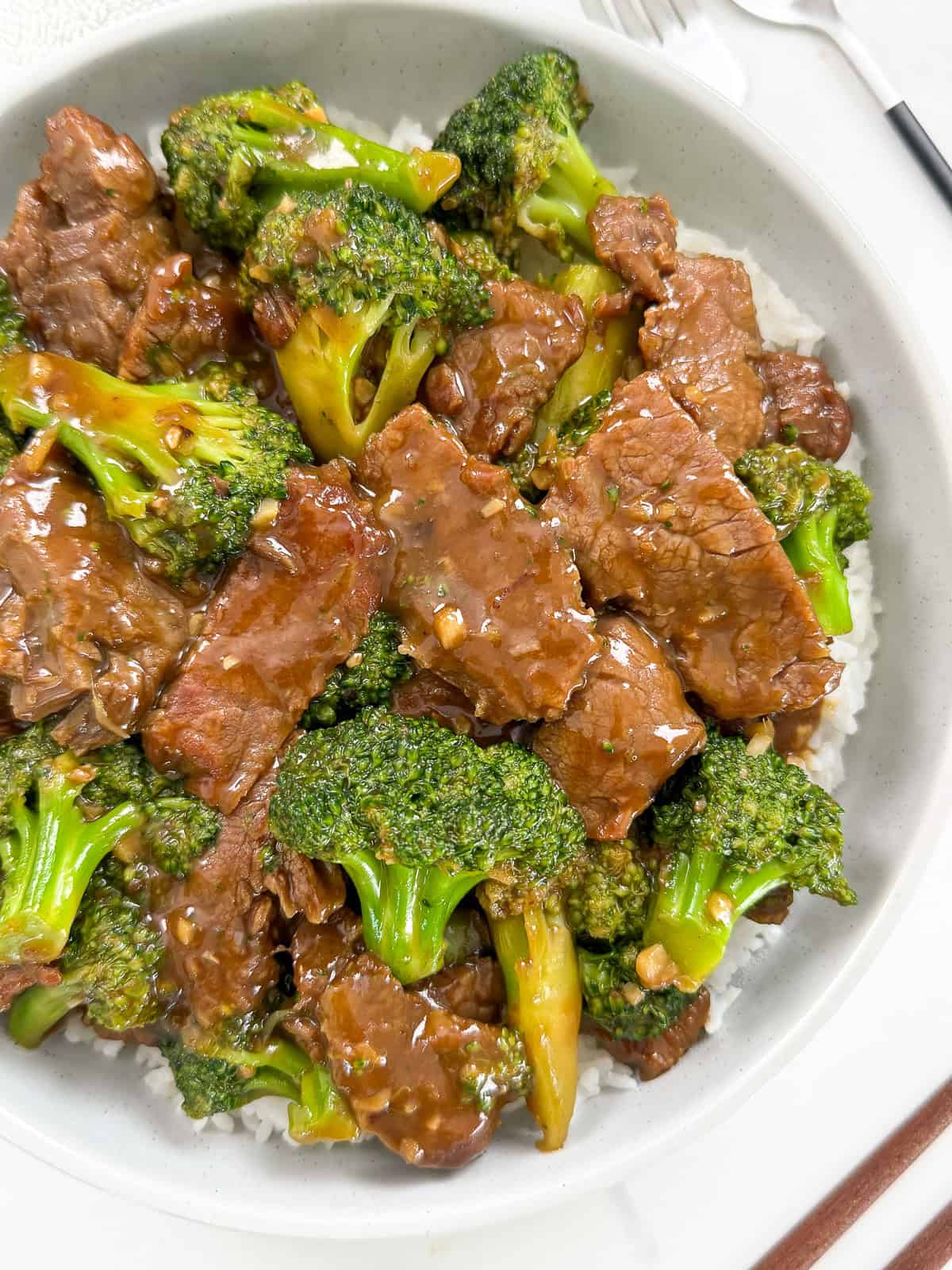 Beef and broccoli over rice in a bowl main view