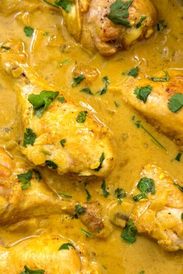 Coconut curry chicken in a large pan featured view