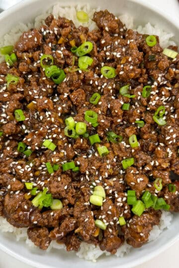 Mongolian ground beef over white rice in a large bowl featured view