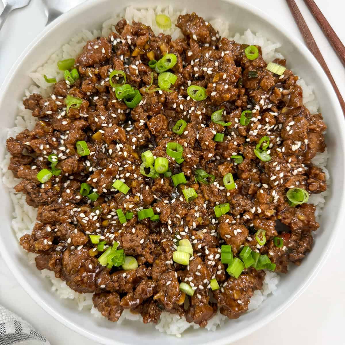 Mongolian ground beef over white rice in a large bowl featured view