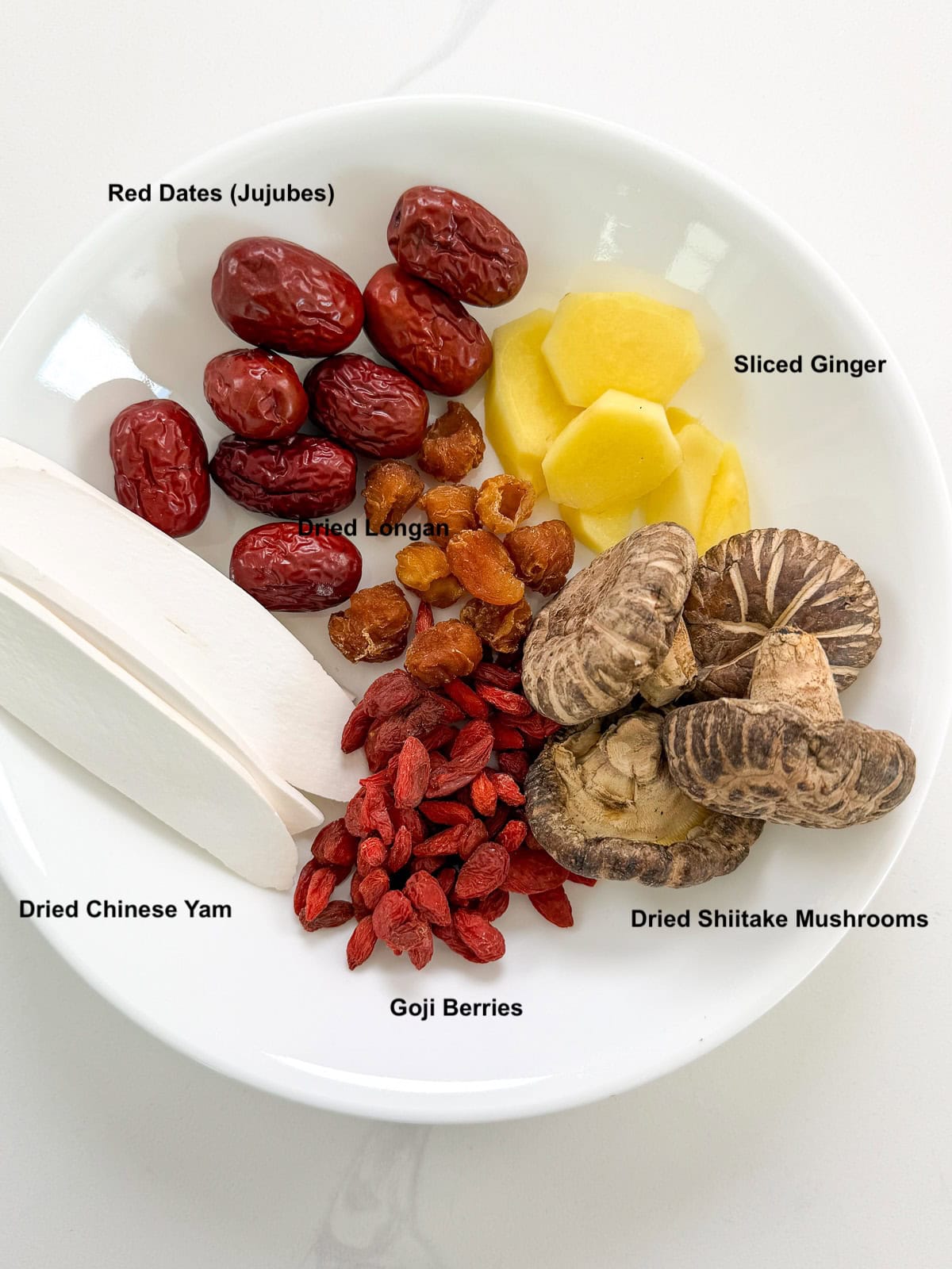 Chinese Chicken Herbal Soup Ingredients with dried Chinese yam, goji berries, dried shiitake mushrooms, dried longan, sliced ginger, and red dates