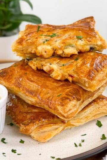 Marry Me Chicken Hot Pockets on a round plate with ranch dipping sauce on the side and chopped parsley on top