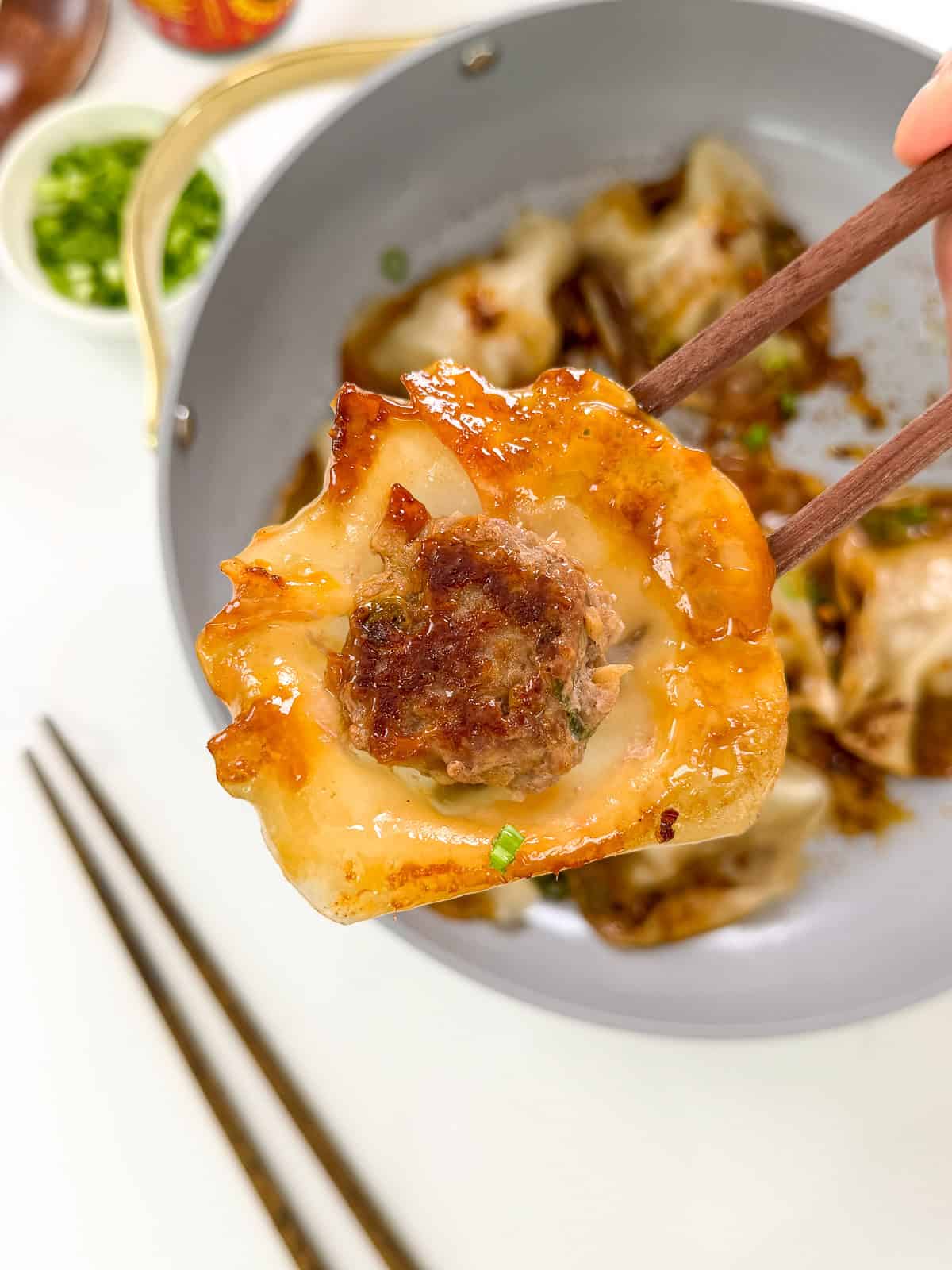 Viral Blanket Dumplings held with chopsticks centered with the meatball exposed